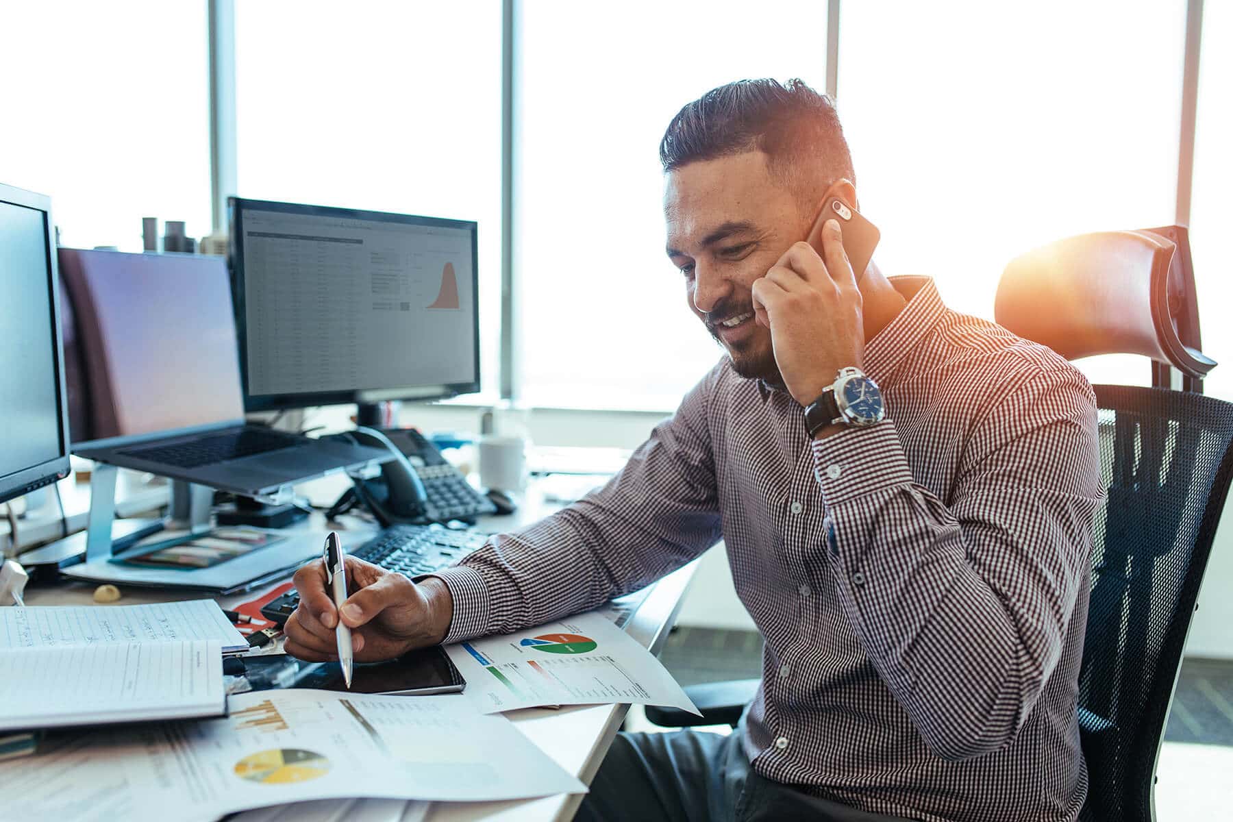 Professional man managing property on phone in an office environment.